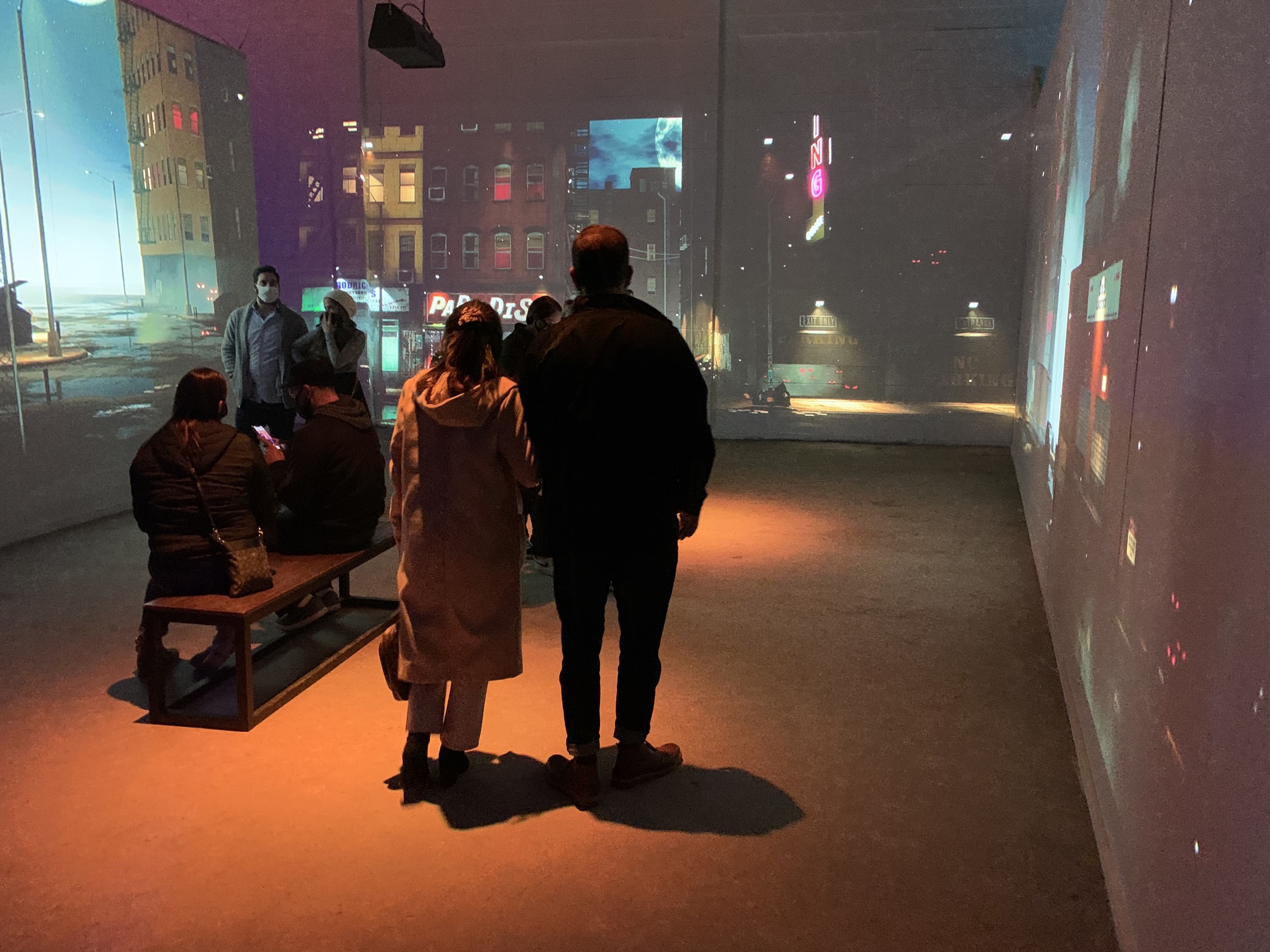 Visitors walking through an immersive projected city environment